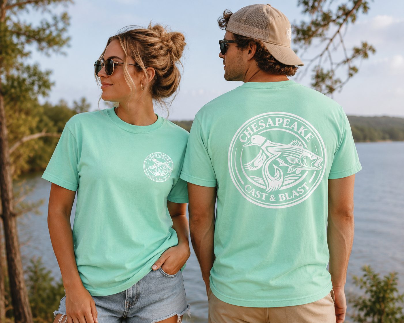 Two guests in Chesapeake Cast and Blast shirts beside the water