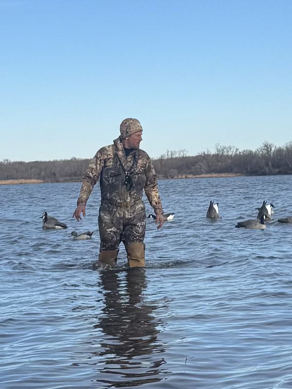 Hunter wading out to set decoys in open water