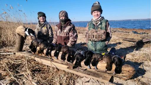 Young hunters beside a shoreline decoy spread